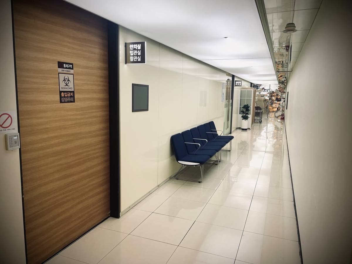 강남세브란스장례식장 안치실 앞 복도 대기공간 안치실 앞 복도와 대기 의자가 보인다.