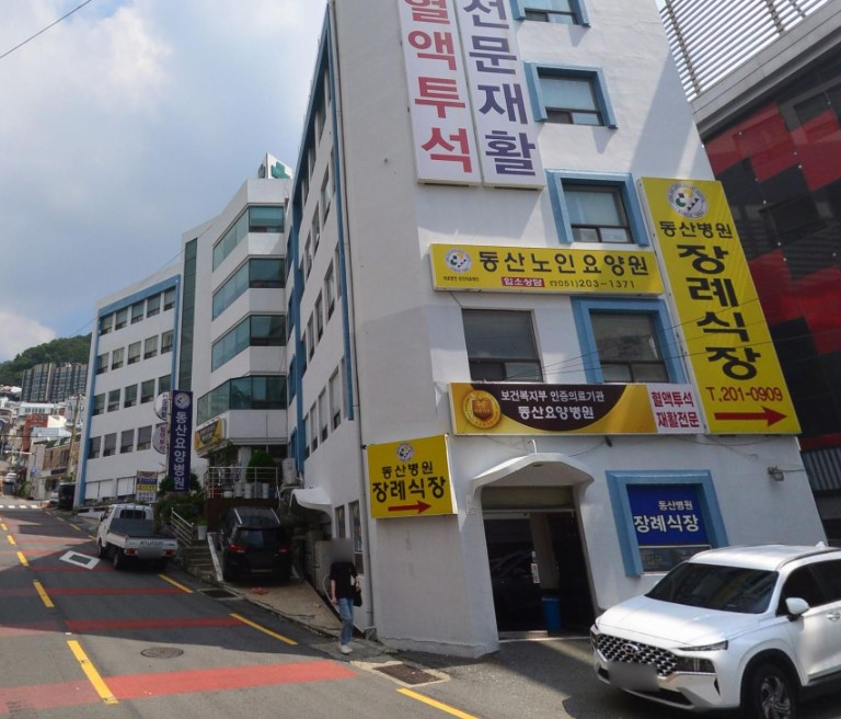 동산병원장례식장 건물과 노란색 안내 간판들